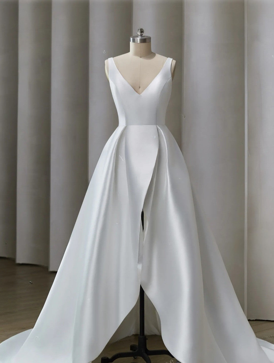 White wedding dress on a mannequin against a plain background