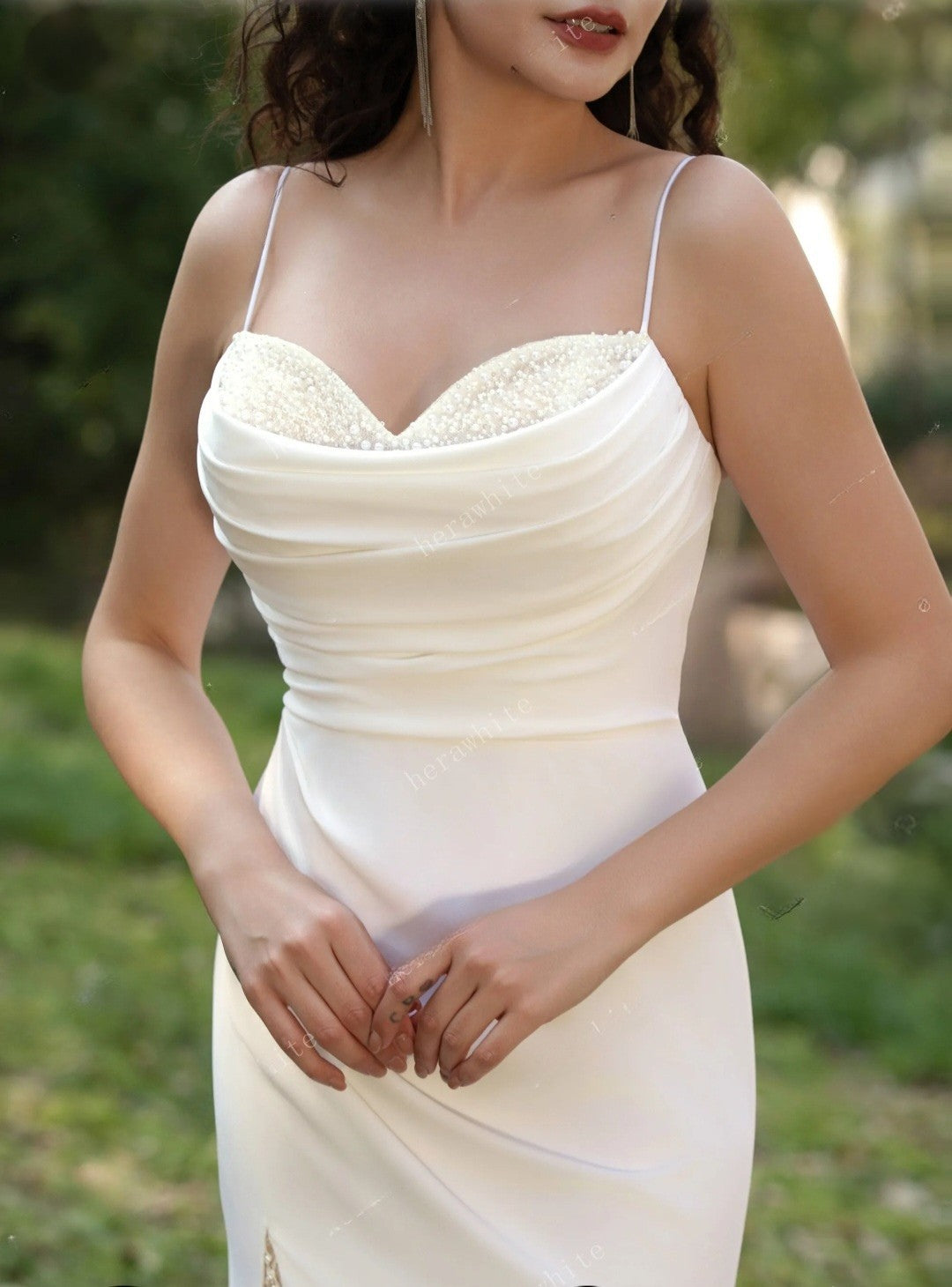 Woman wearing a white dress with a blurred green background