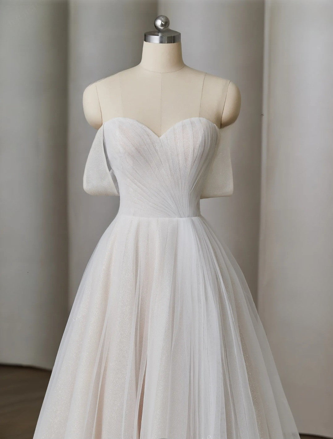 White tulle dress on a mannequin against a plain background