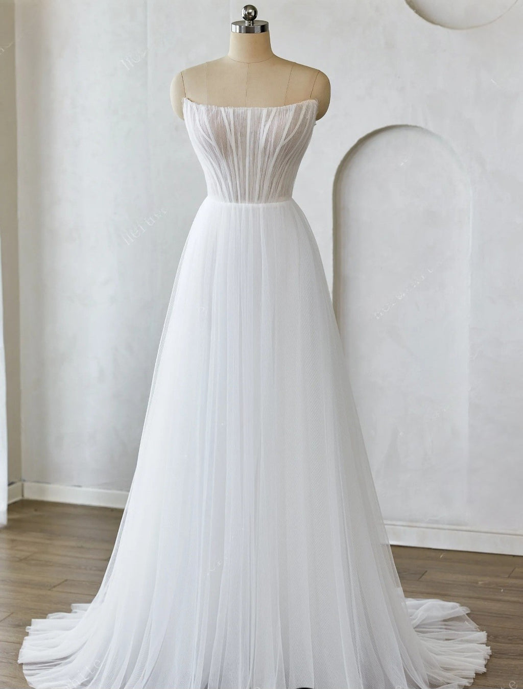 White strapless gown on a mannequin against a plain background
