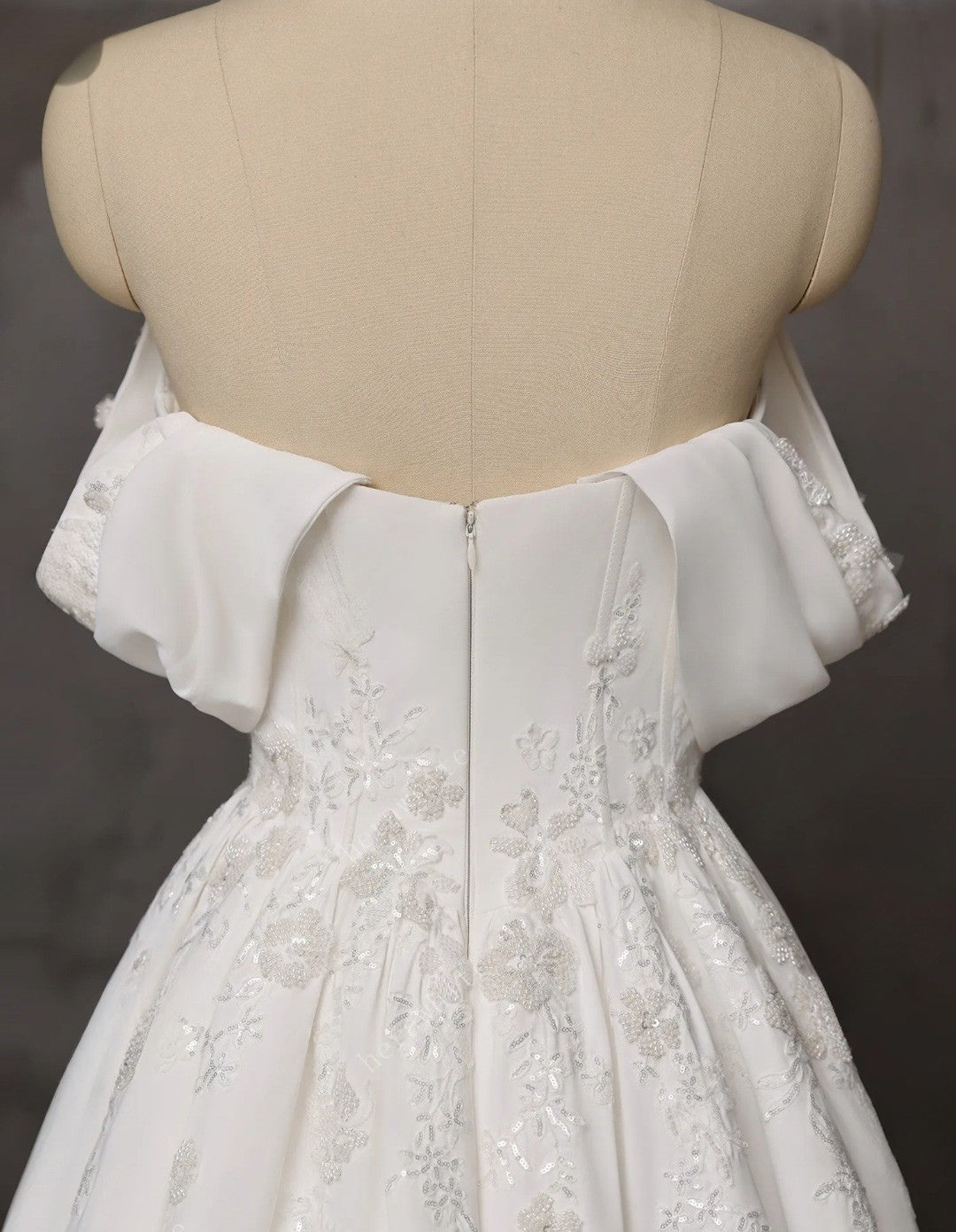 White lace dress on a mannequin against a dark background