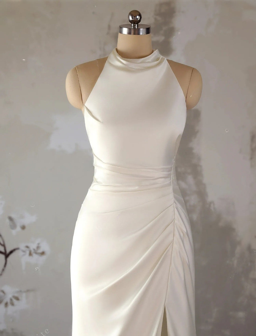 White evening gown on a mannequin against a neutral background