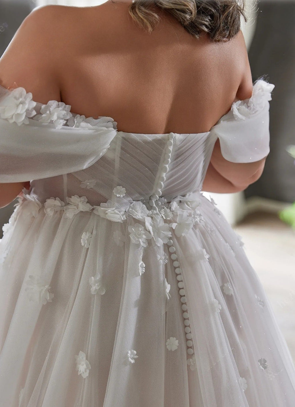 White wedding dress with floral details on a blurred background
