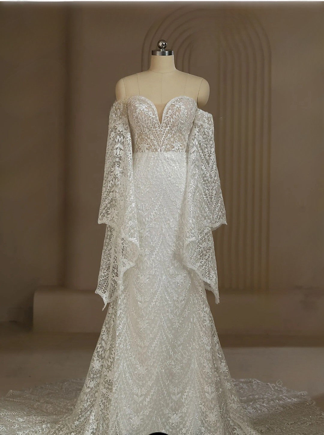 Lace wedding dress on a mannequin against a neutral background