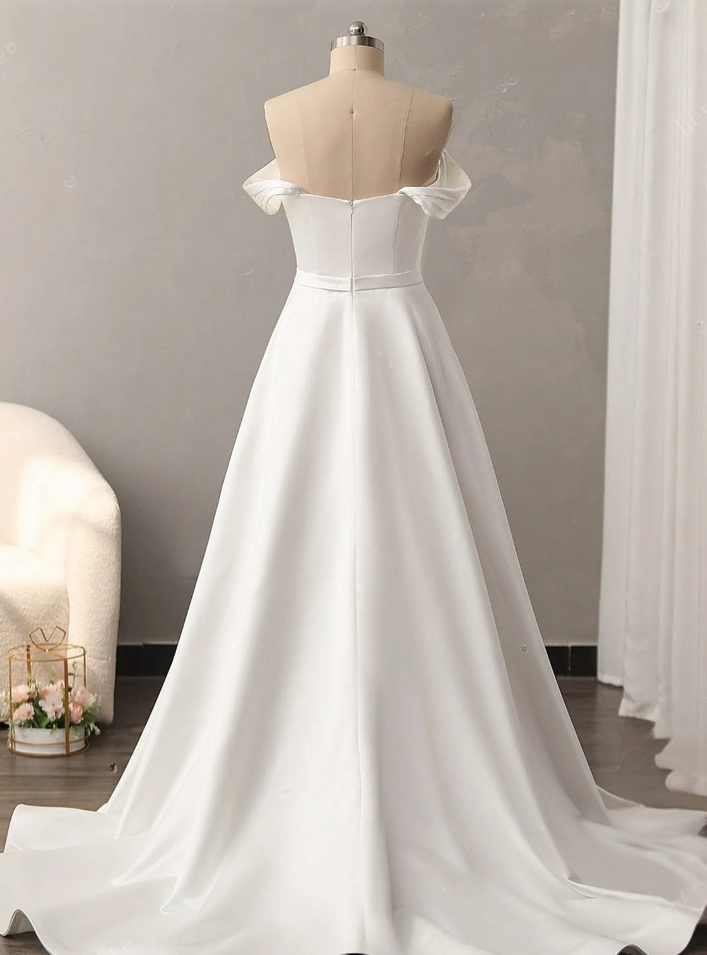 White wedding dress on a mannequin against a neutral background