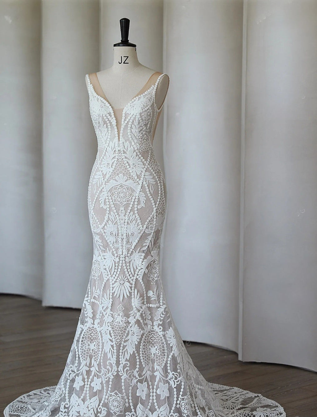 White lace dress on a mannequin against a plain background