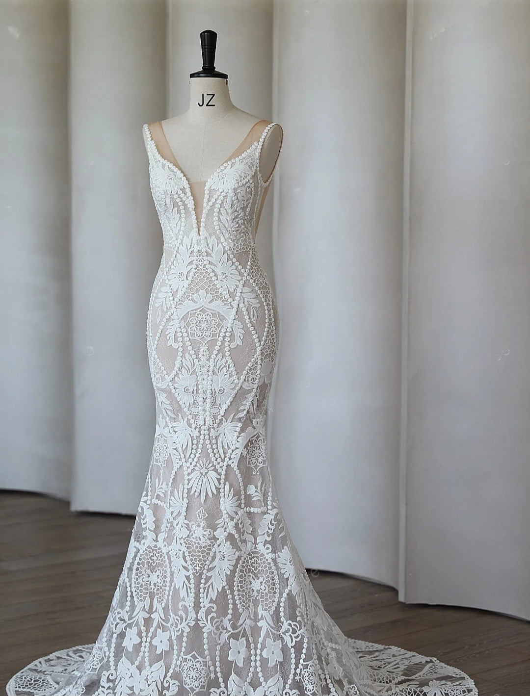 White lace dress on a mannequin against a plain background