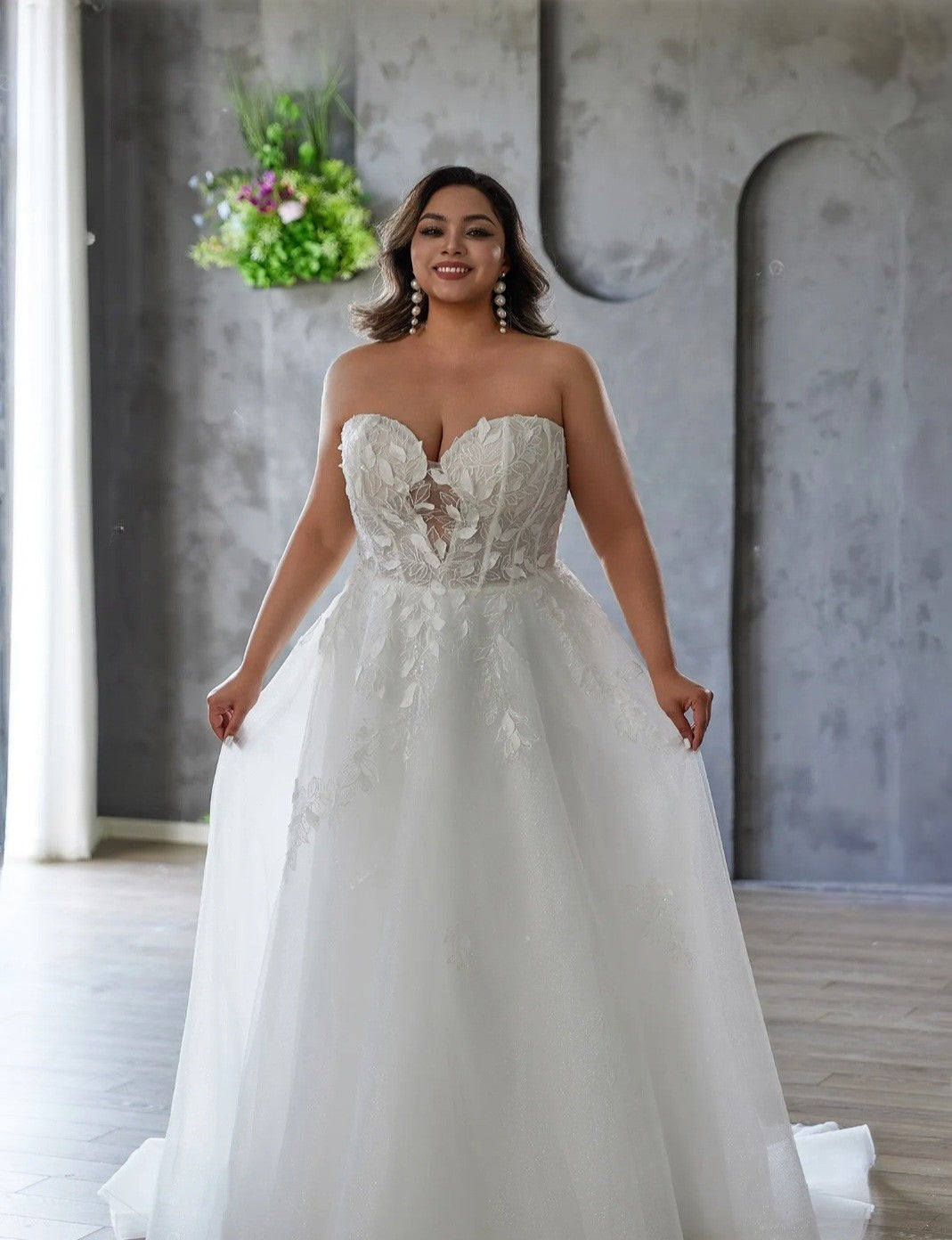 Woman wearing a white wedding dress in an indoor setting with a neutral background