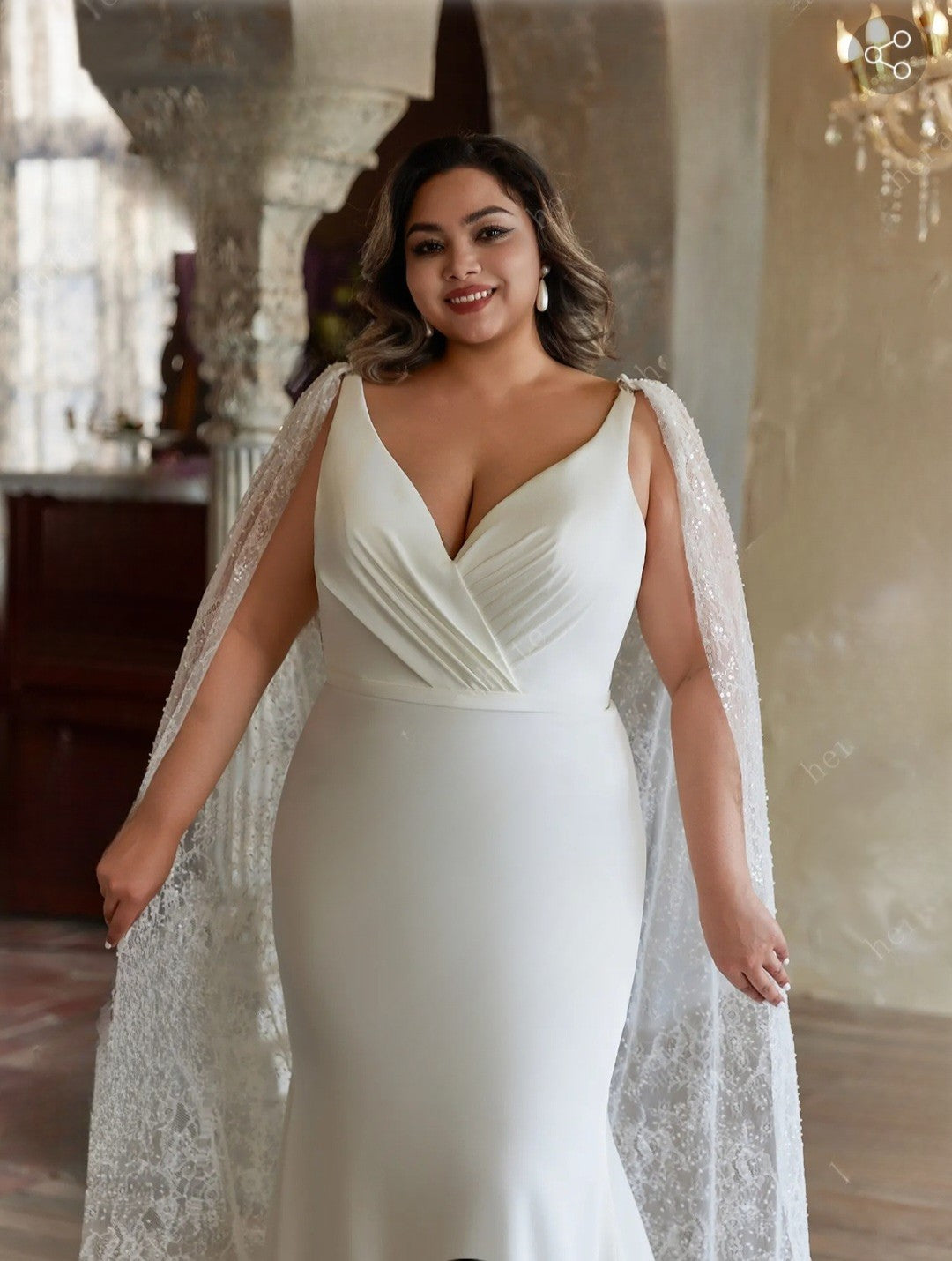 Woman wearing a white gown with a lace cape in an elegant indoor setting
