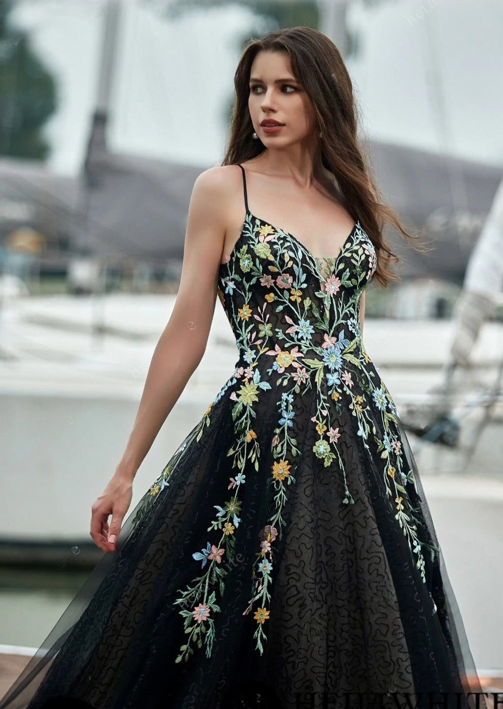 Woman wearing a black floral dress with a blurred background