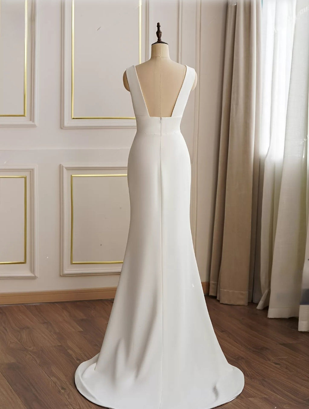White evening gown on a mannequin against a neutral background