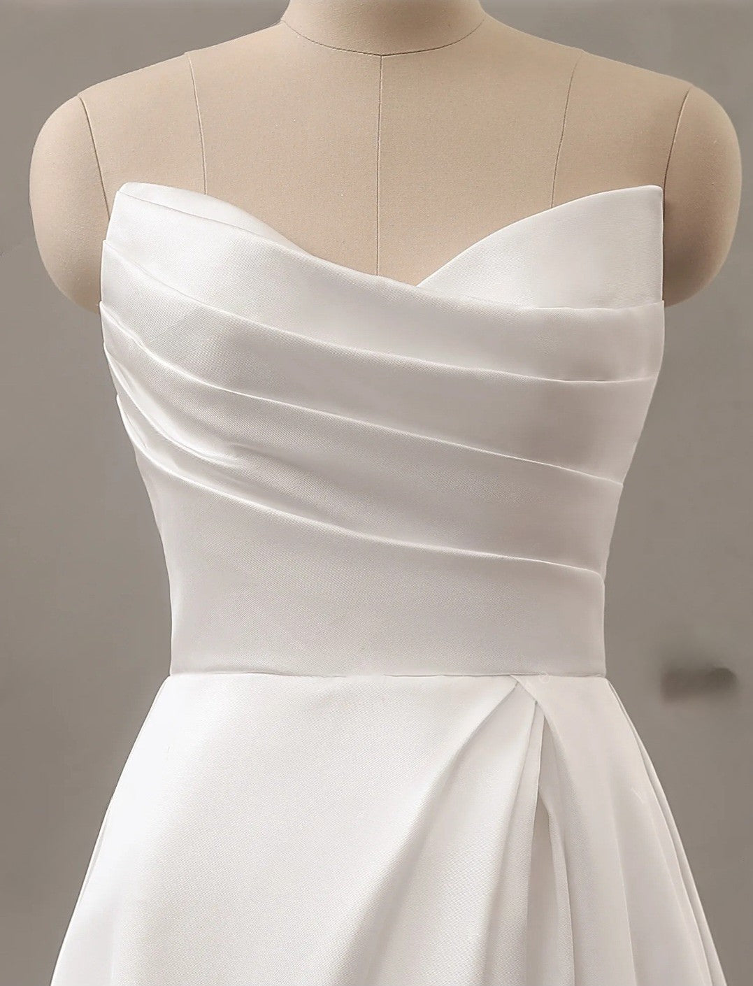 White strapless dress on a mannequin against a neutral background