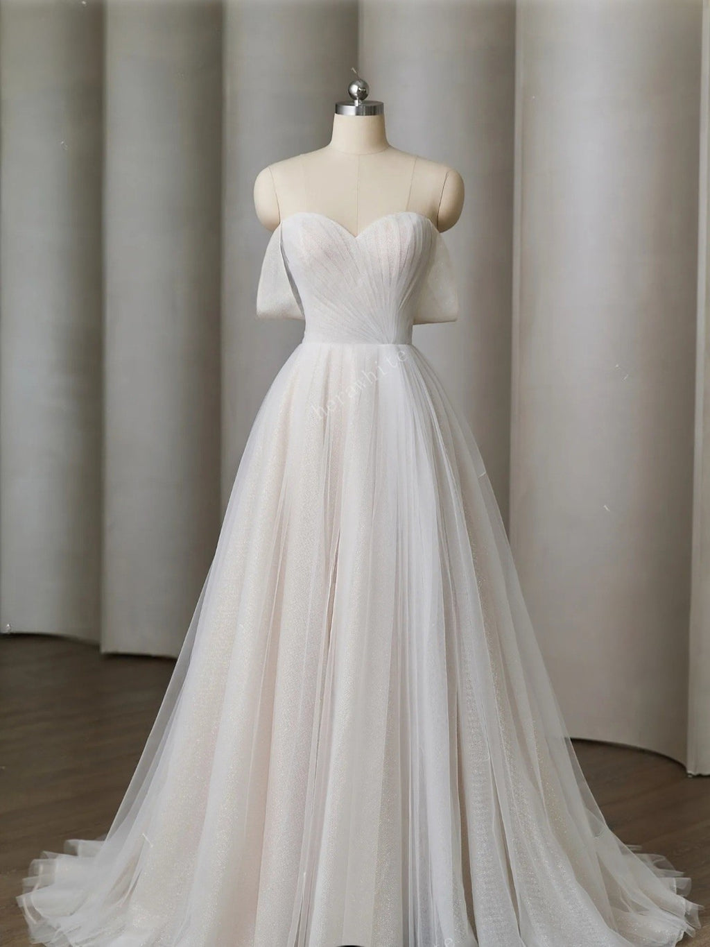 White wedding dress on a mannequin against a neutral background
