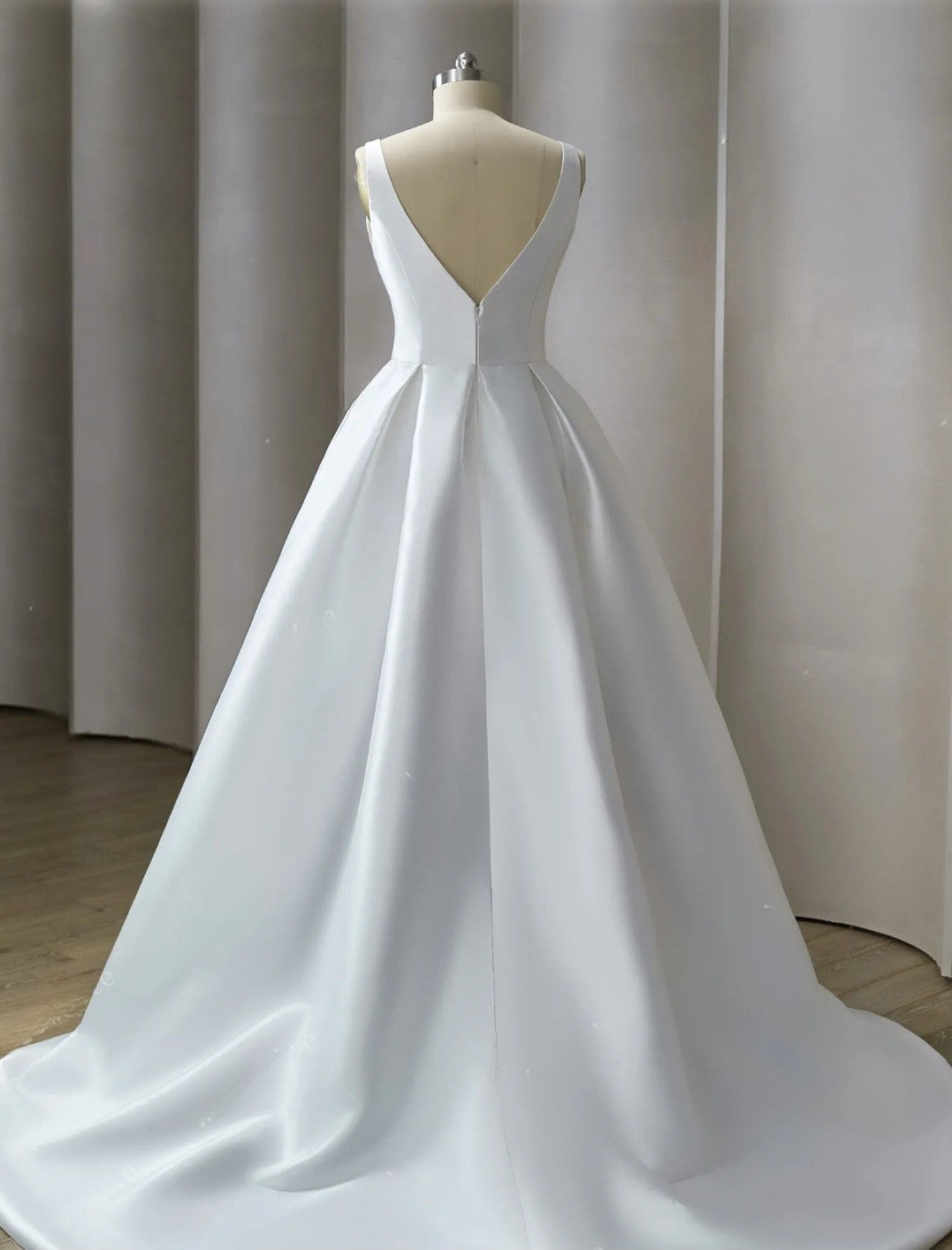 White wedding dress on a mannequin against a neutral background