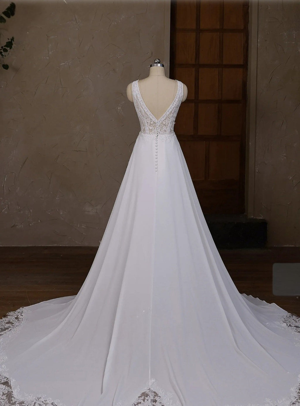 White wedding dress on a mannequin against a neutral background