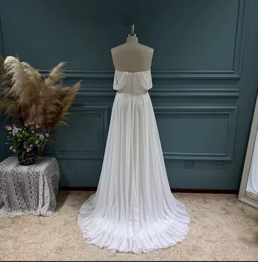 White evening gown on a mannequin against a dark blue wall.