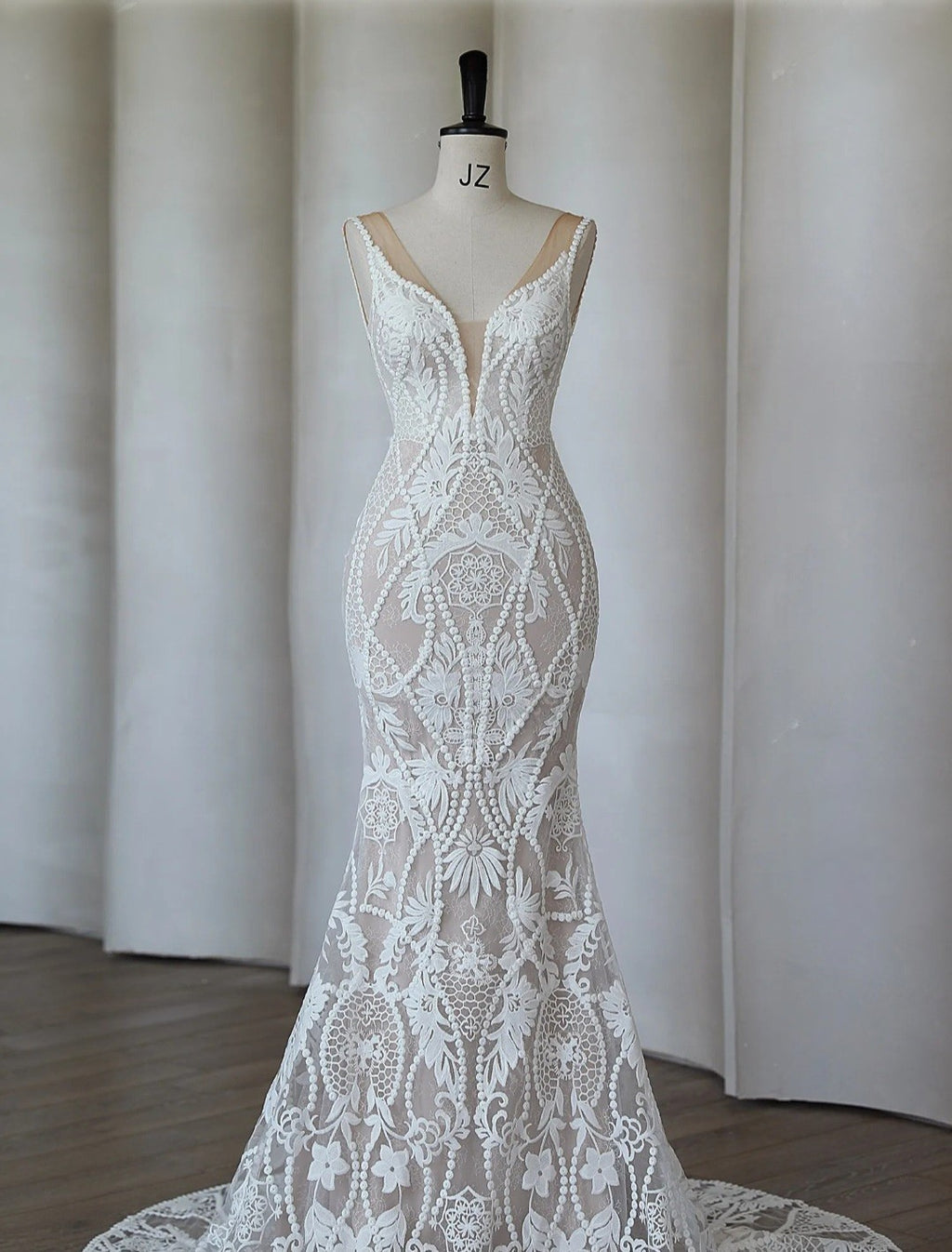 White lace dress on a mannequin against a plain background