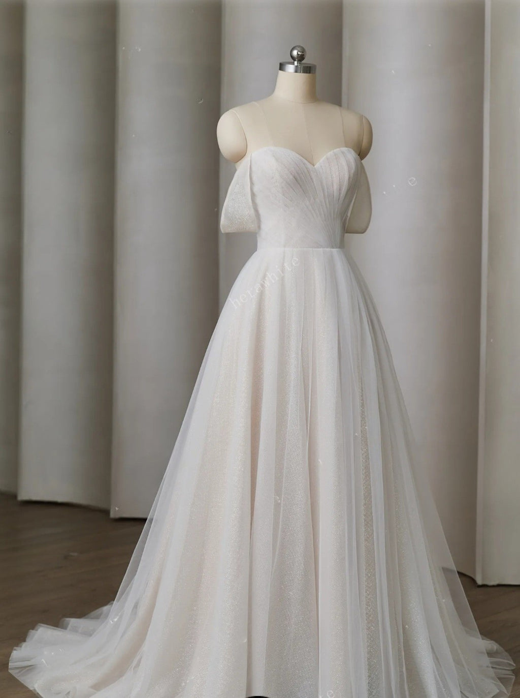 White wedding dress on a mannequin against a plain background