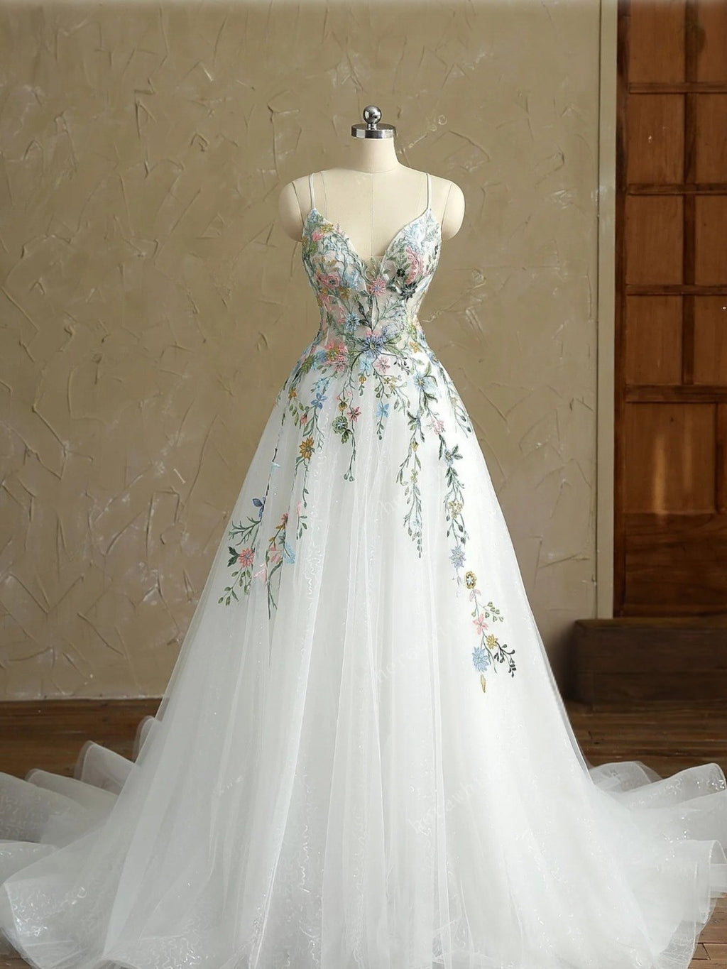 Elegant floral dress on a mannequin against a neutral wall.