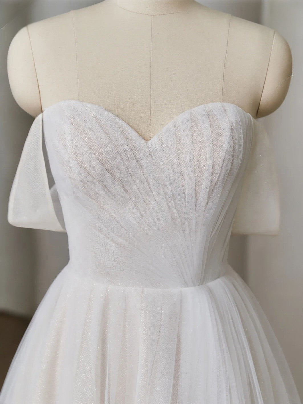 White dress on a mannequin against a neutral background