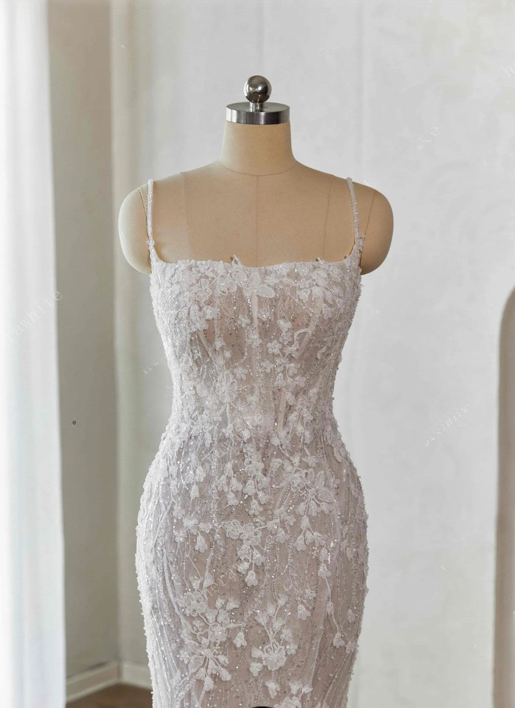 Lace dress on a mannequin against a plain background