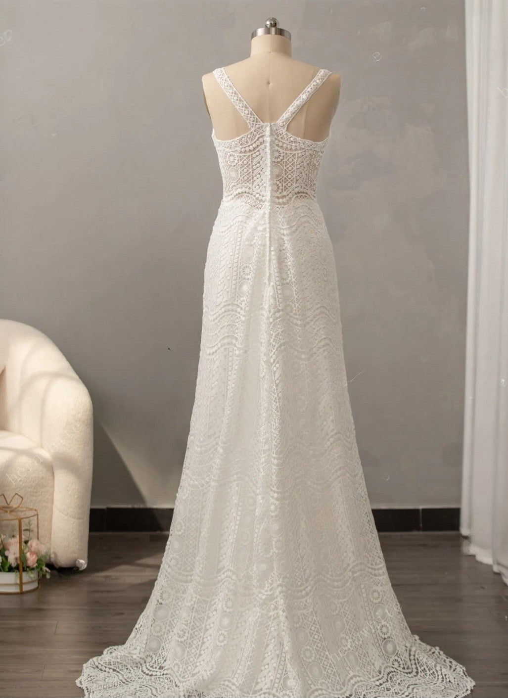 White lace wedding dress on a mannequin against a neutral background