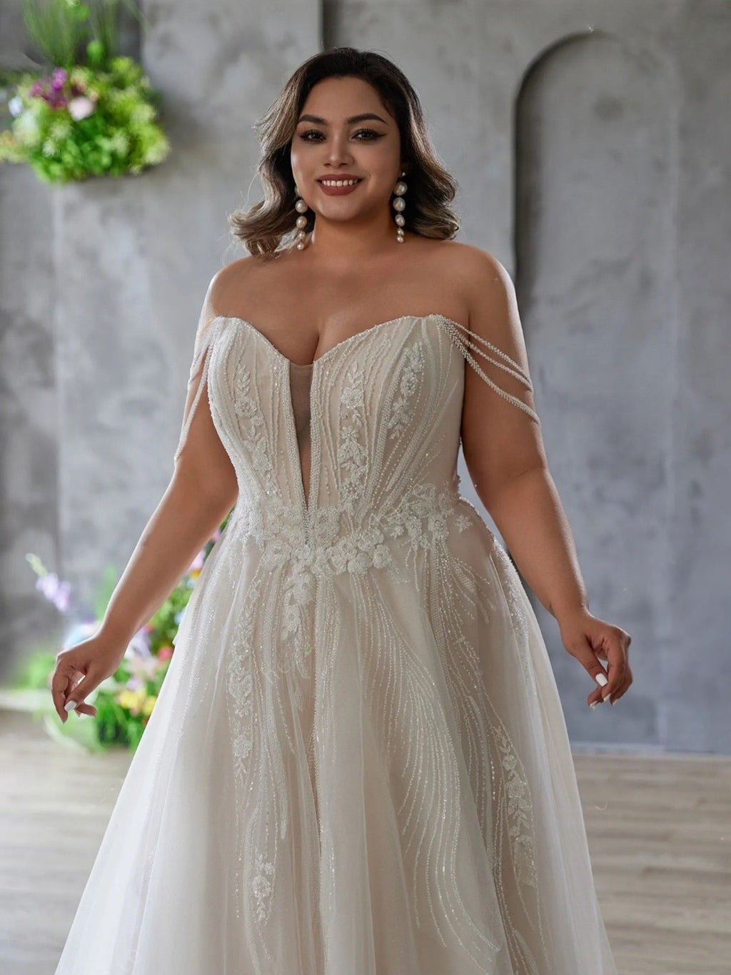 Woman wearing a white lace wedding dress in an indoor setting with a neutral background