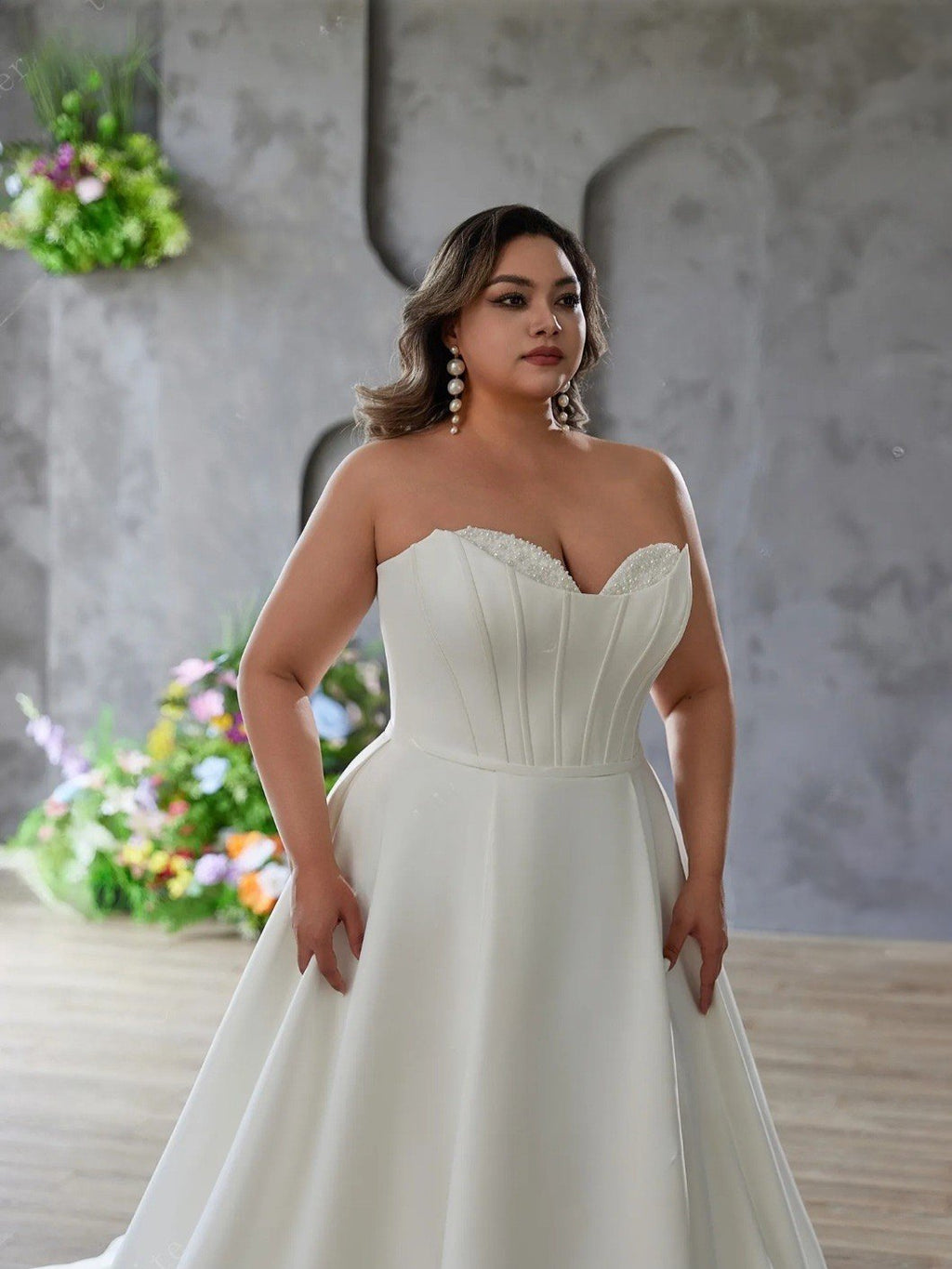 Woman wearing a strapless white wedding dress in a decorated indoor setting.