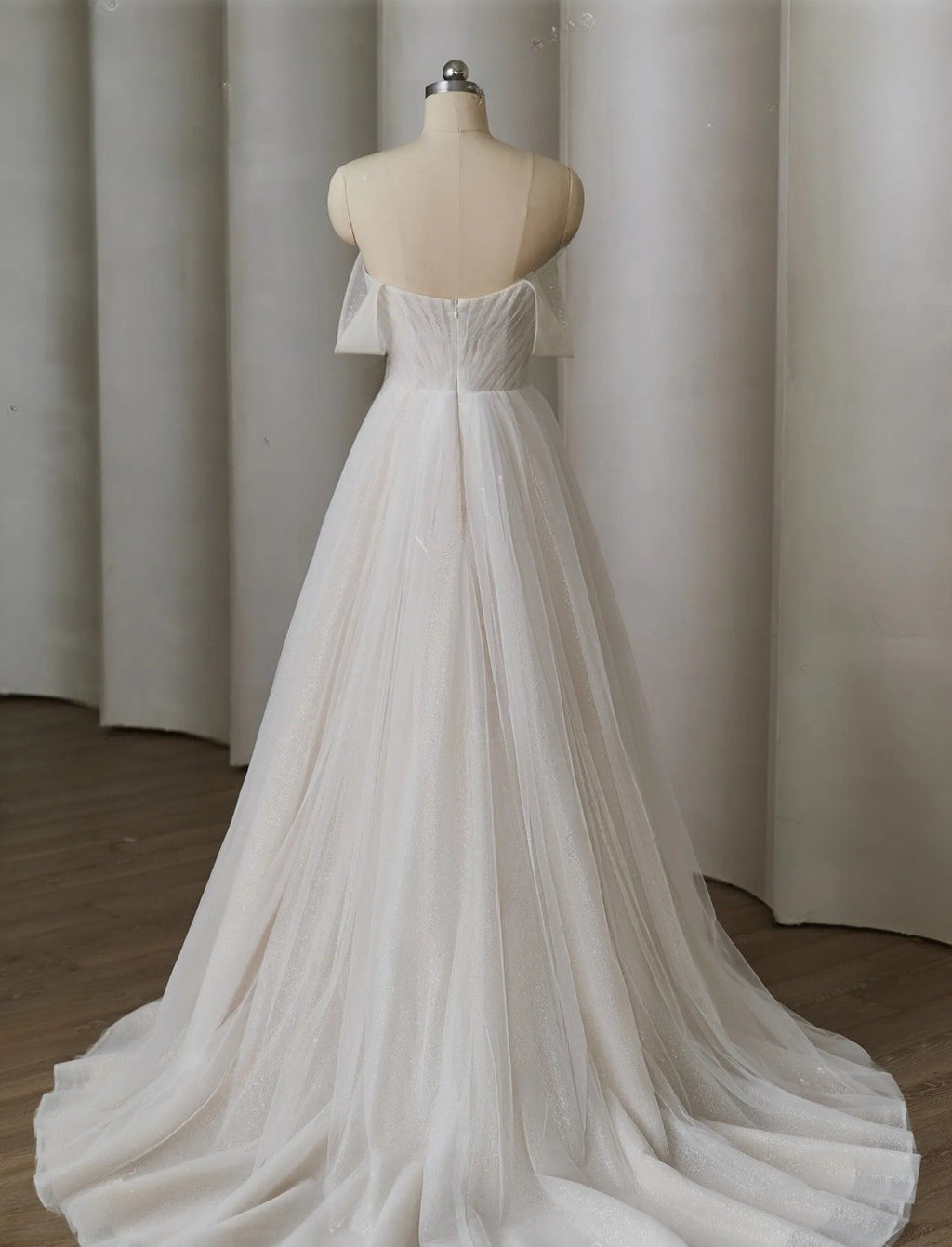 White wedding dress on a mannequin against a plain background