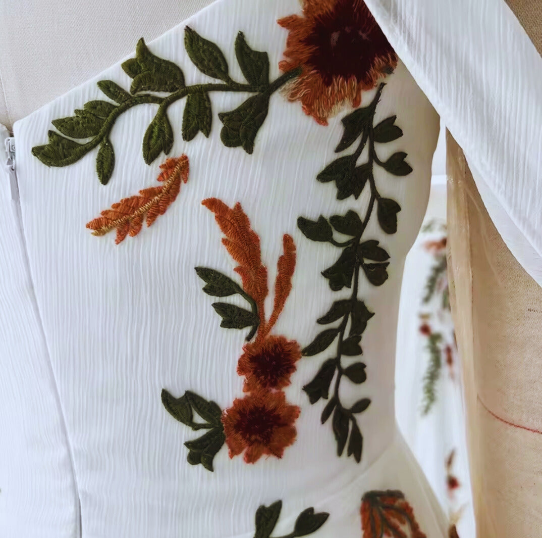 Embroidered floral design on a white fabric background