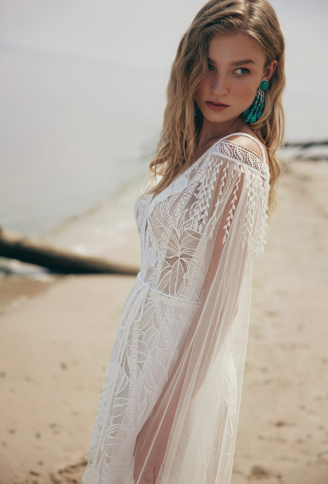Woman wearing a white lace dress on a beach