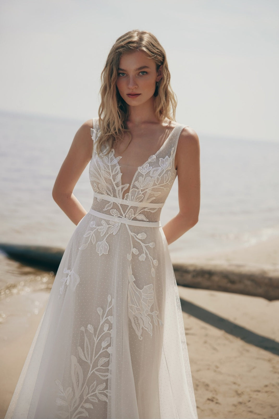 Woman wearing a white lace dress on a beach