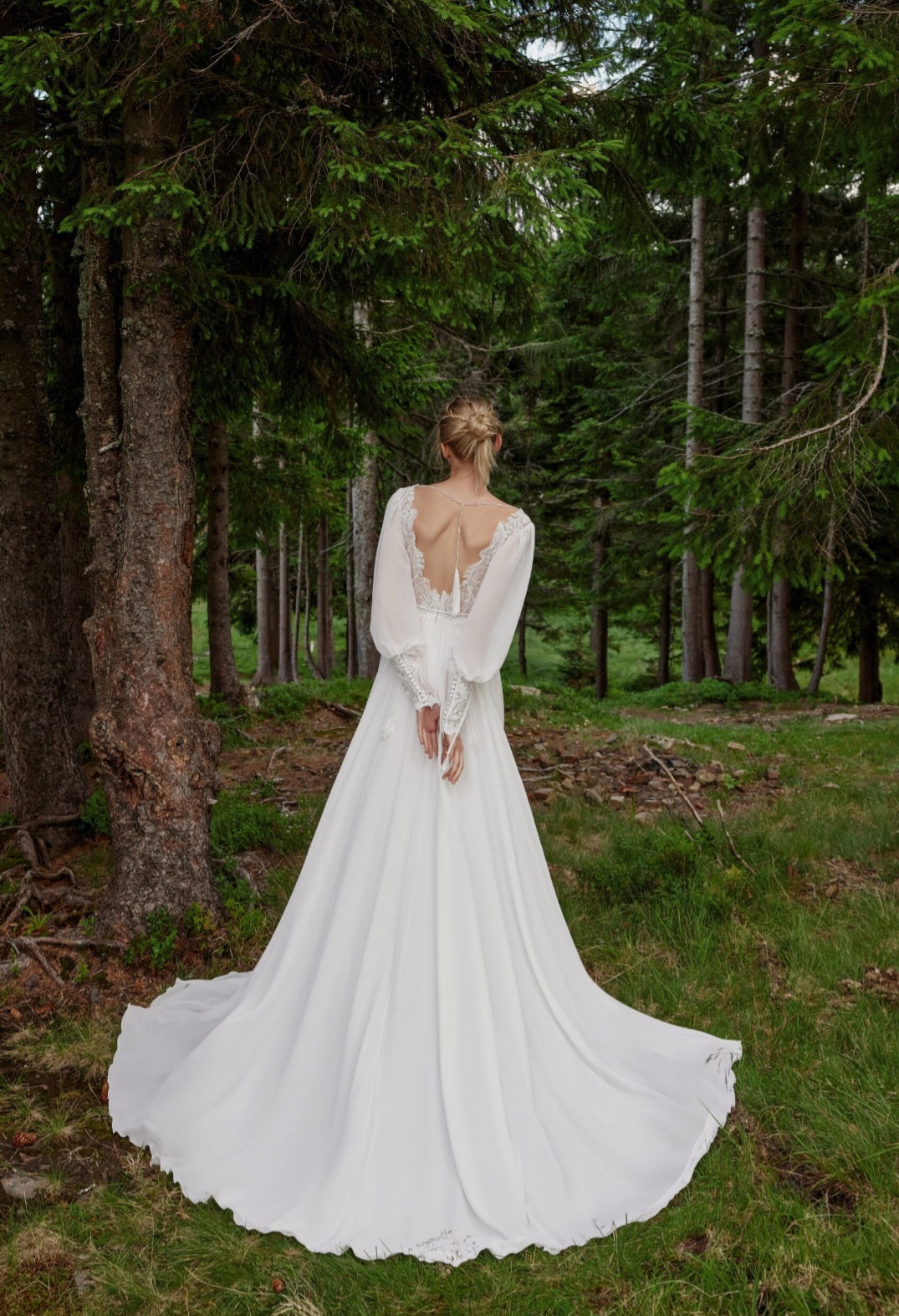 Woman in a white wedding dress standing in a forest