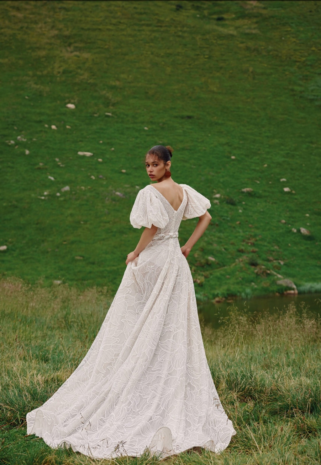 Woman in a white dress standing in a grassy field