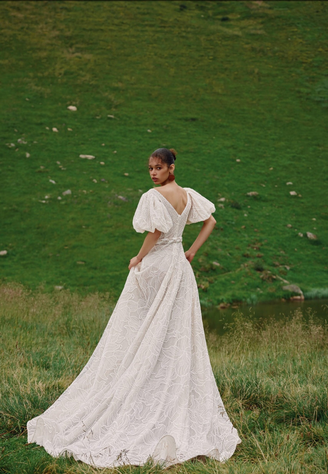 Woman in a white dress standing in a grassy field