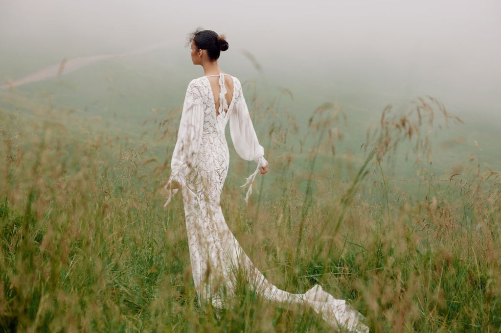 Woman in a white dress standing in a misty field
