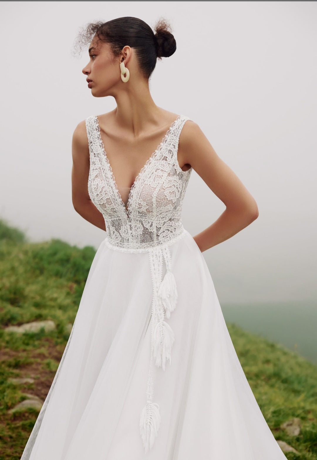 Woman wearing a white lace wedding dress in a natural setting