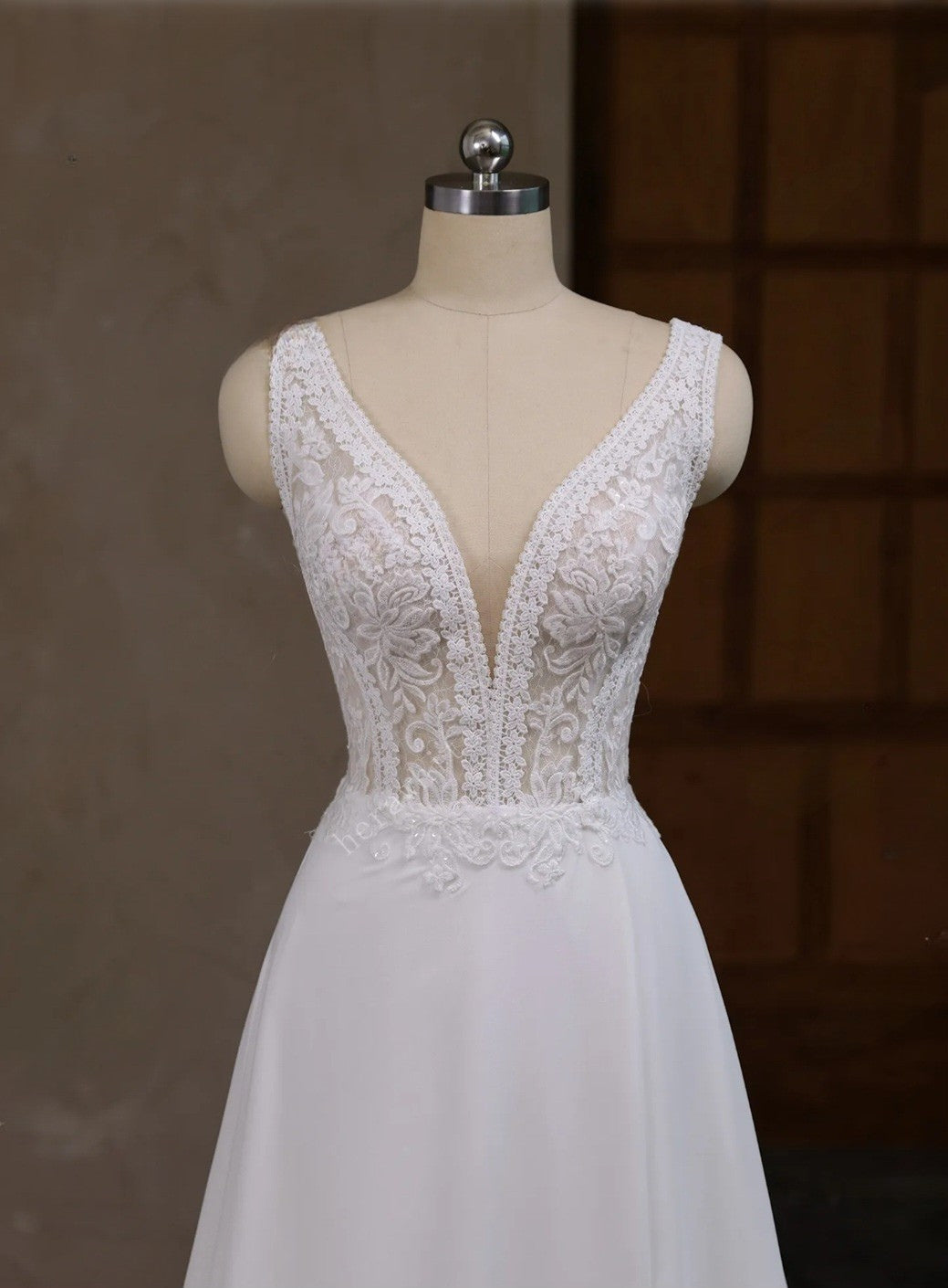 White lace wedding dress on a mannequin against a dark background