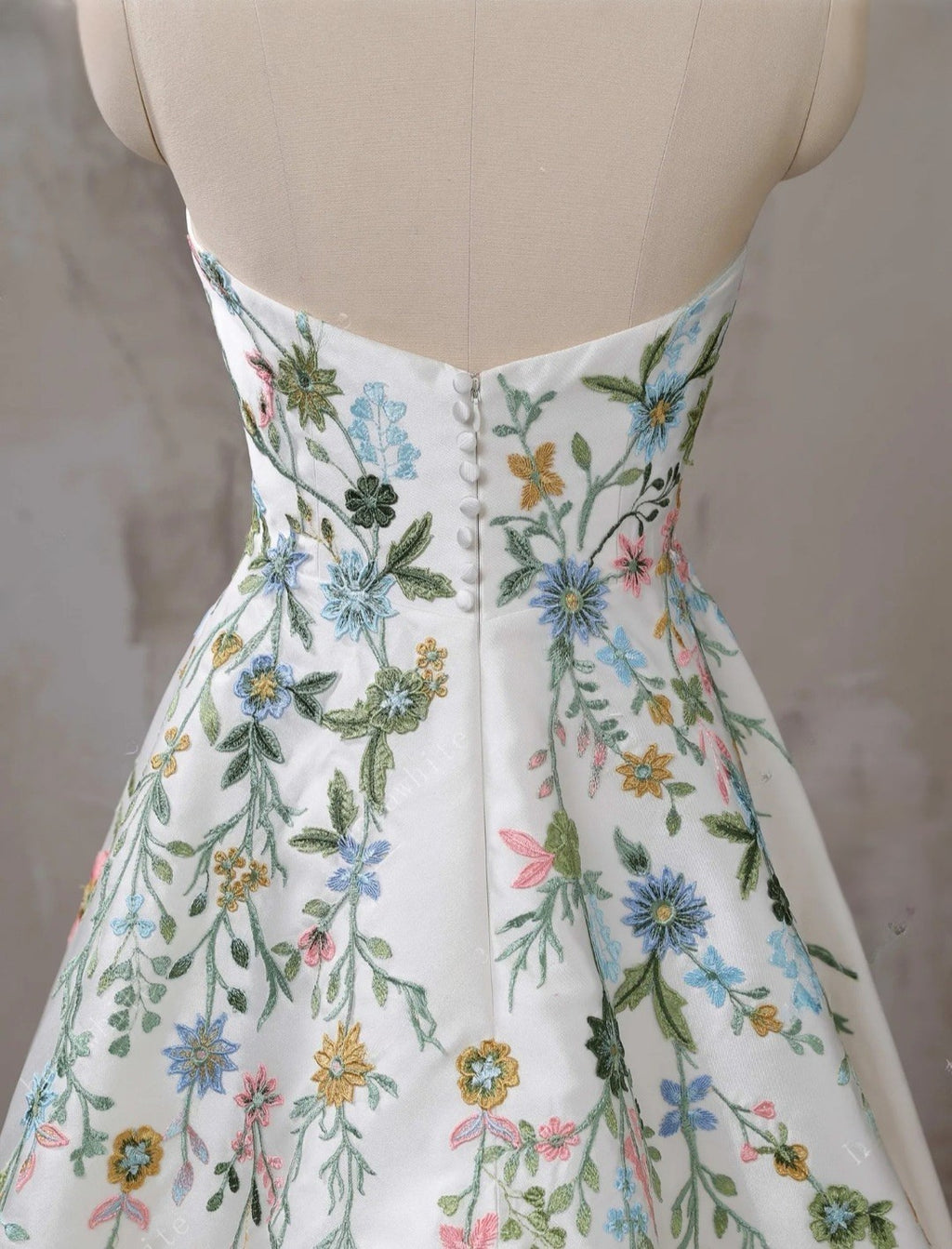 Mannequin wearing a floral embroidered dress with a neutral background