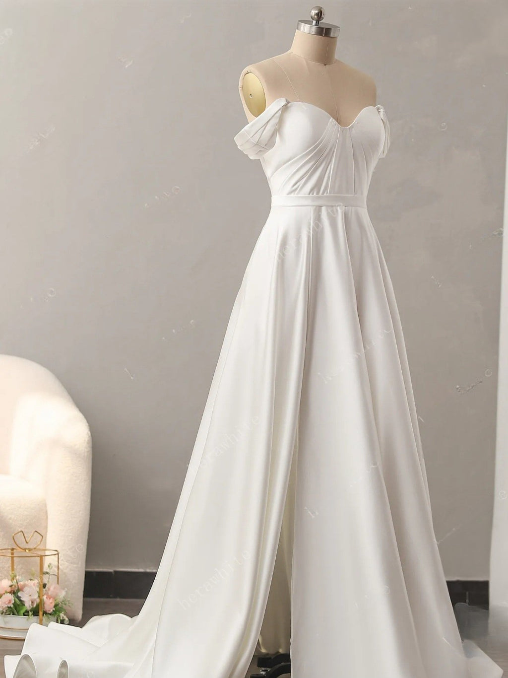 White wedding dress on a mannequin against a plain background