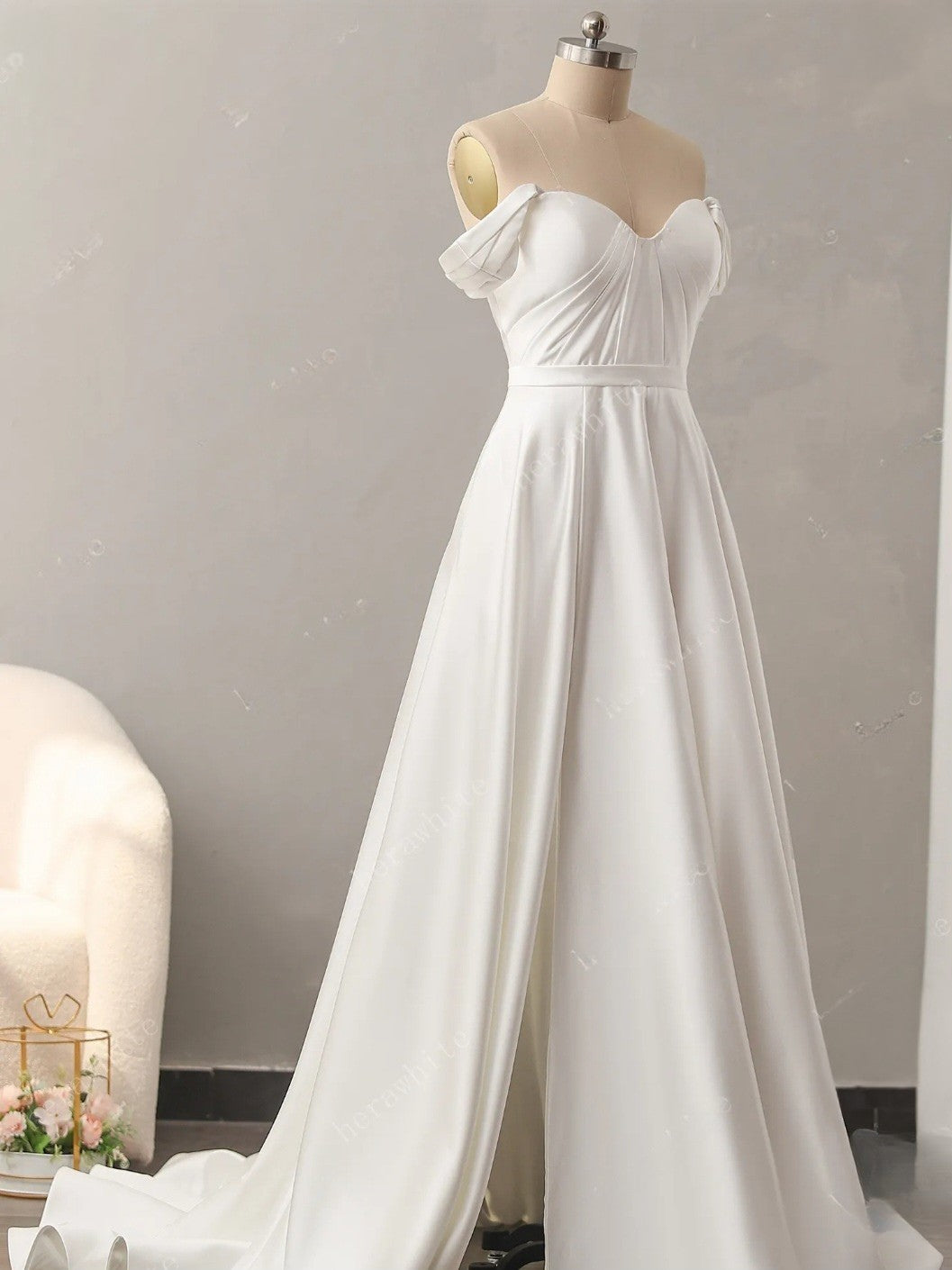 White wedding dress on a mannequin against a plain background