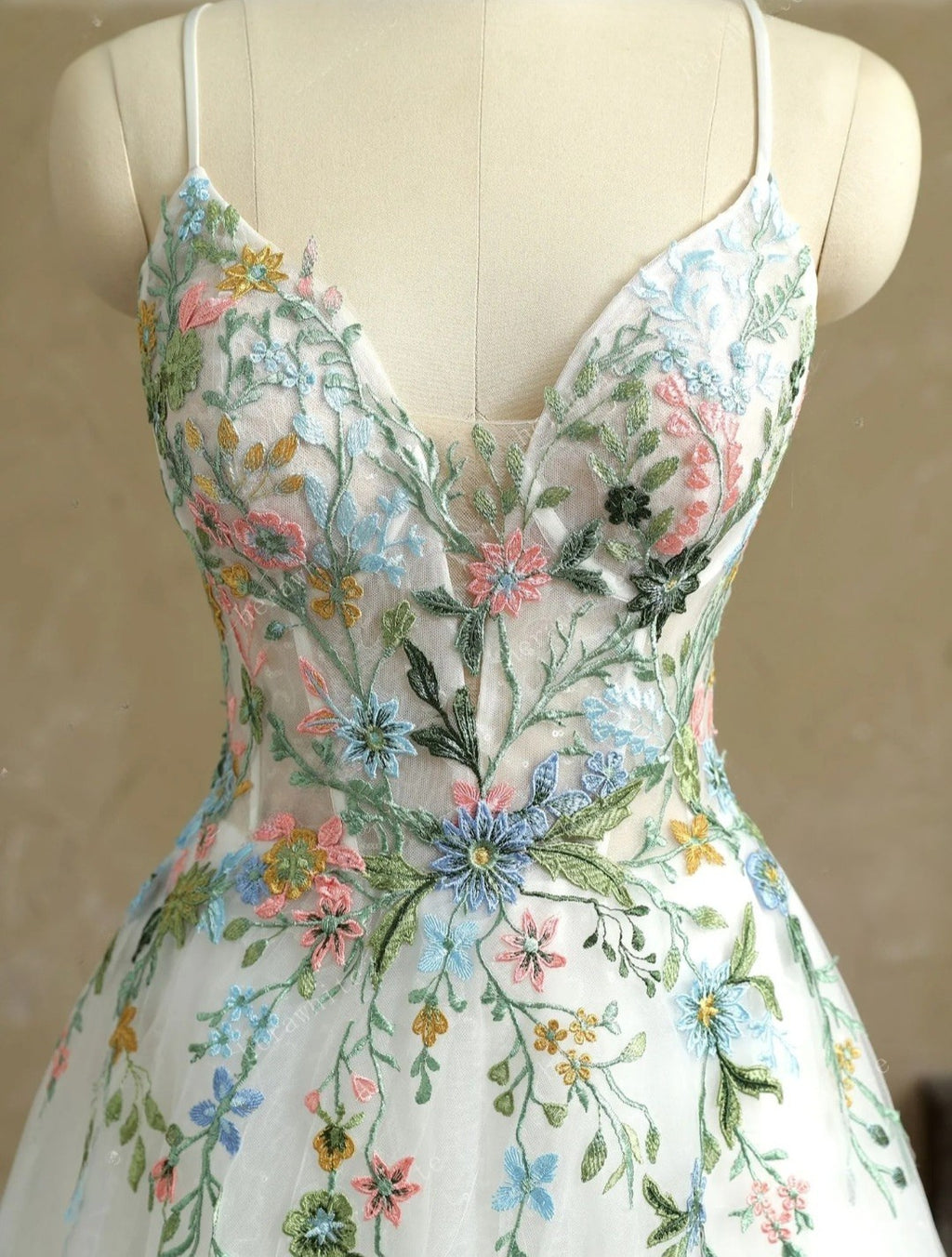 Floral embroidered dress on a mannequin against a neutral background
