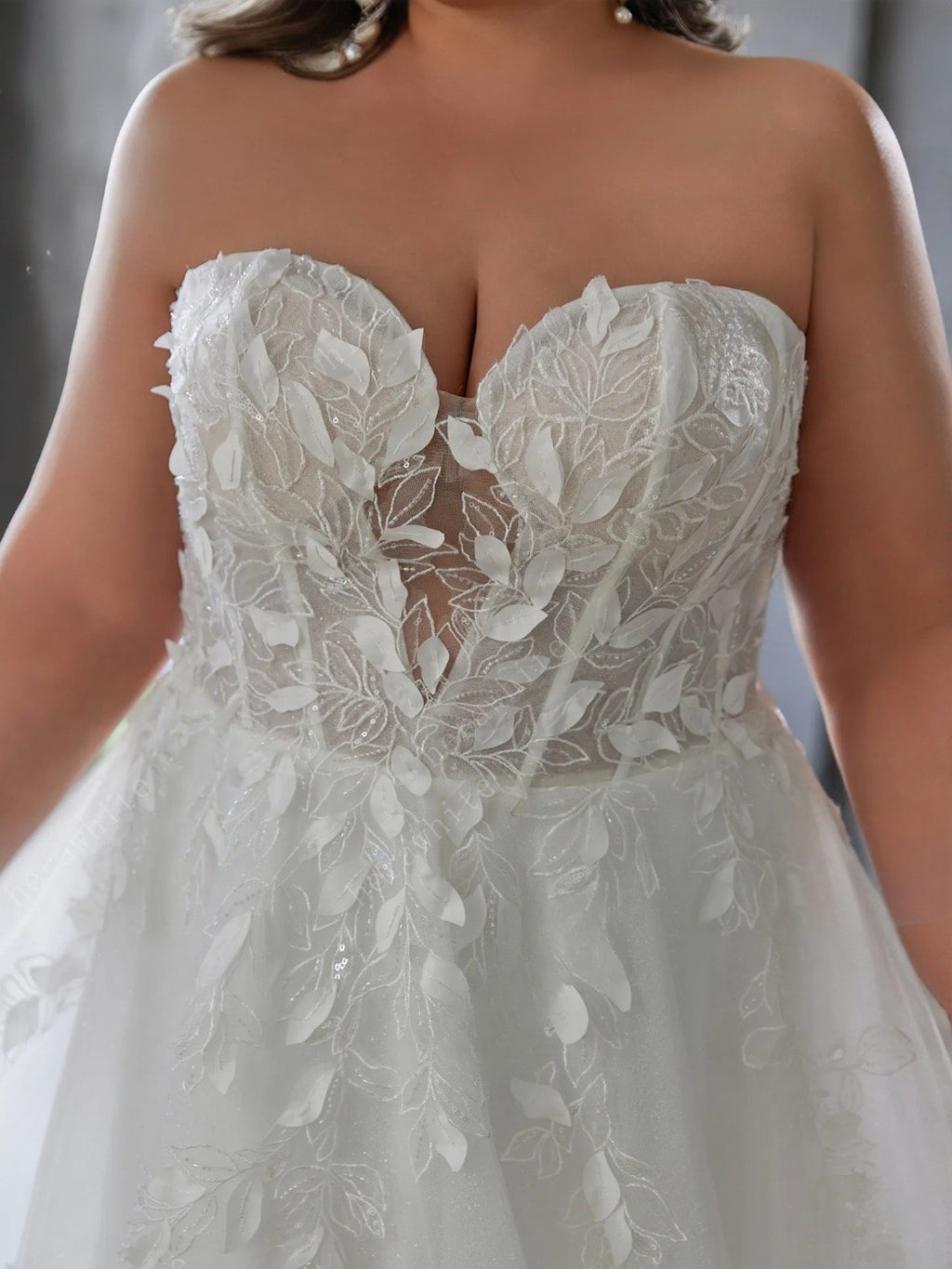 White lace wedding dress with a close-up of the bodice.