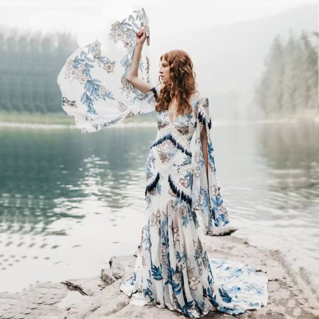 Woman in a floral dress standing by a lake with a blurred background
