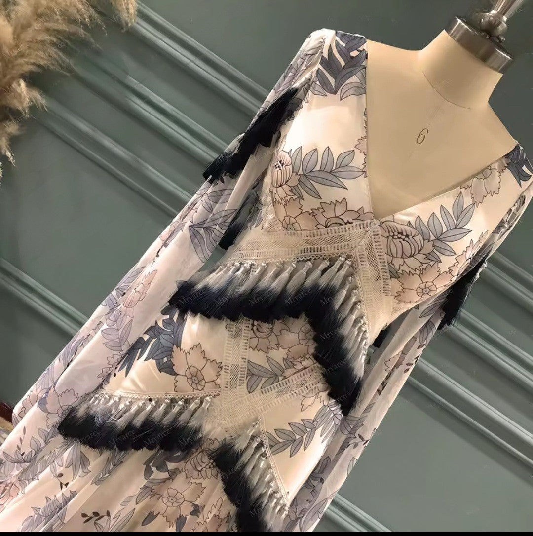 Floral-patterned coat with black accents on a mannequin against a green wall.