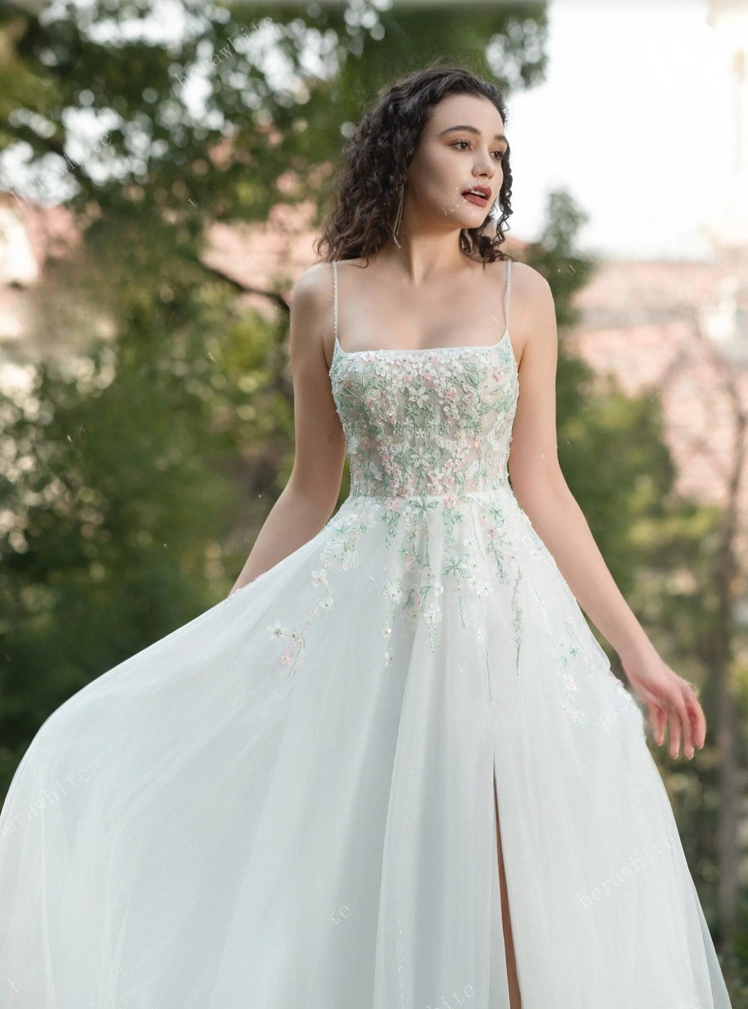 Woman wearing a light blue wedding dress with floral embellishments outdoors.