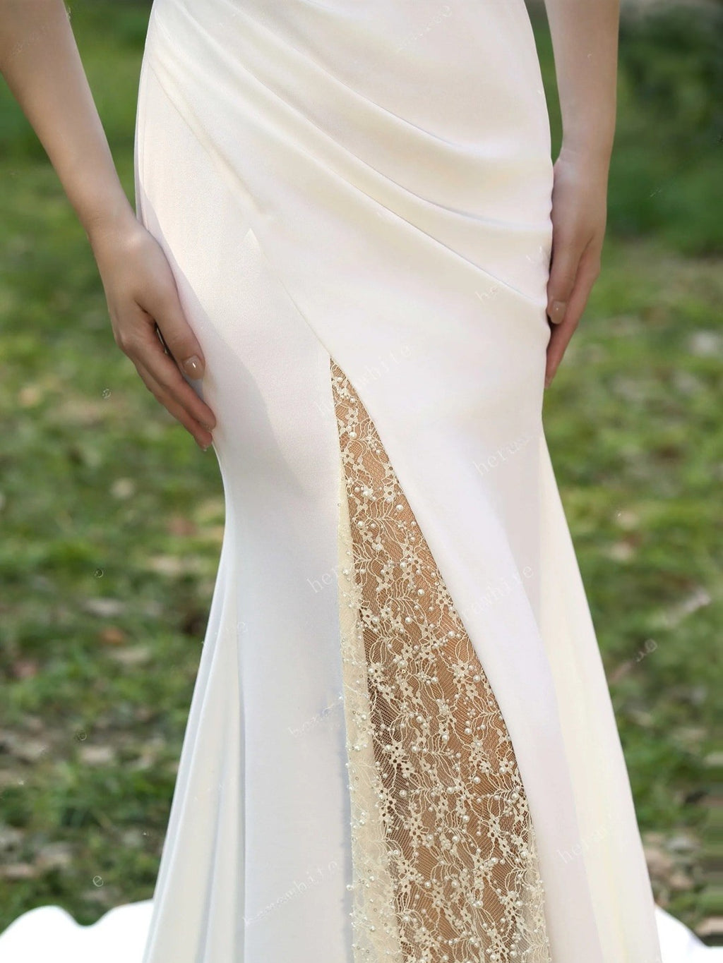 White dress with lace detailing on a grassy background