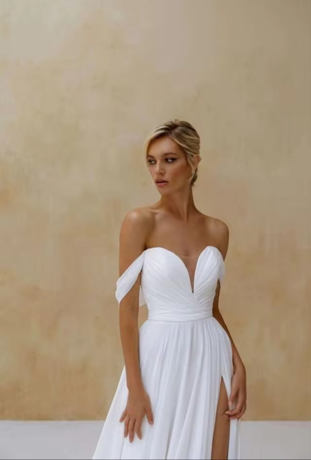 Woman wearing a white strapless dress with a plain background