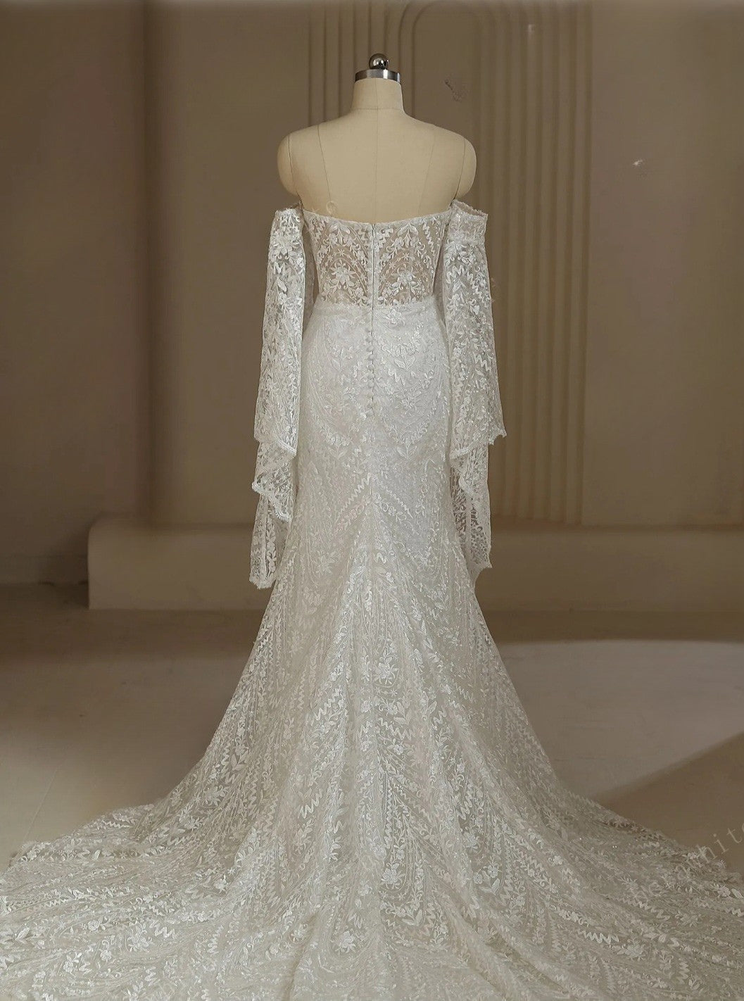 Elegant lace wedding dress on a mannequin against a neutral background
