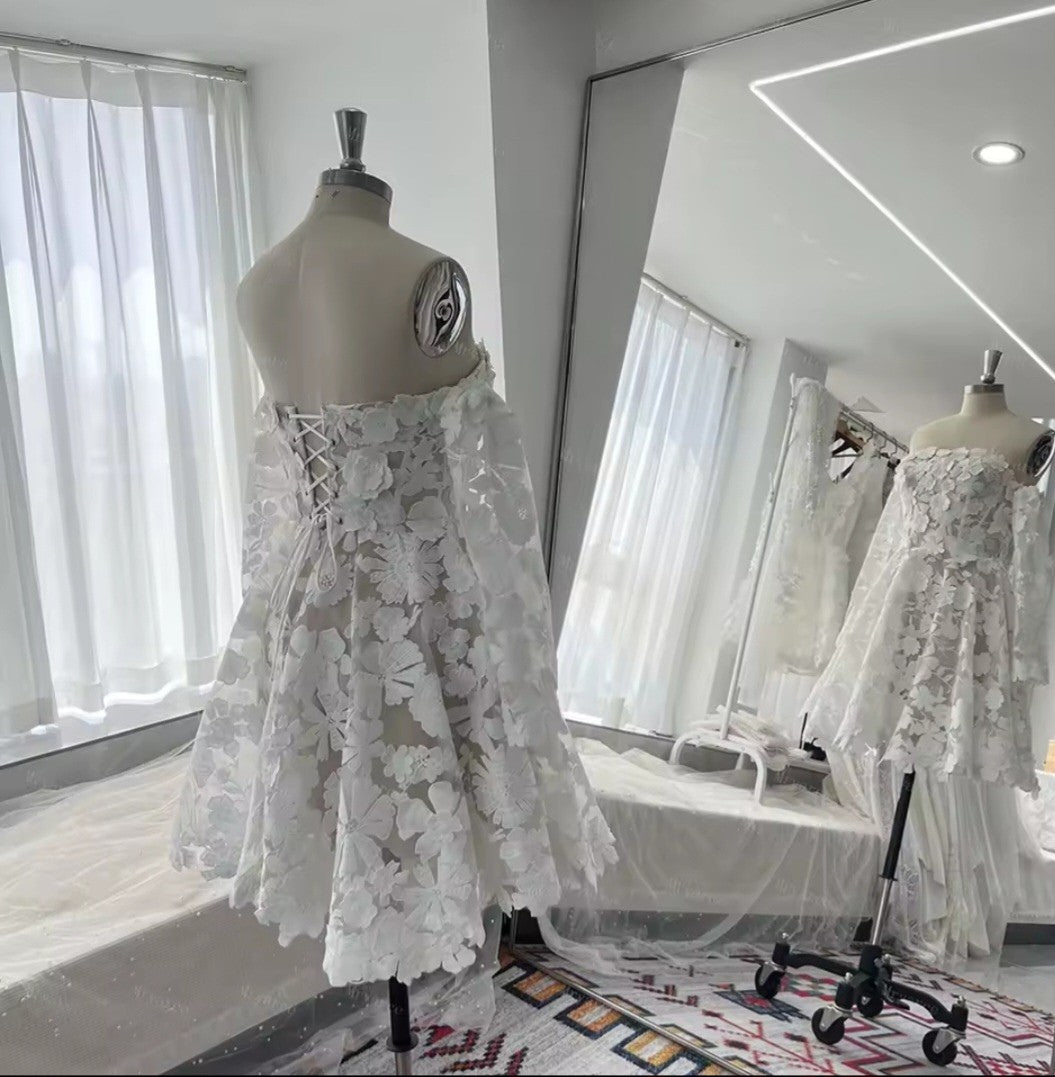 White lace dress on a mannequin in a bright room with large windows.